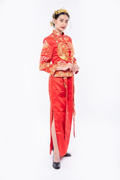 Mujer usa traje Cheongsam promueve para dar la bienvenida a los viajeros de compras en el año nuevo chino