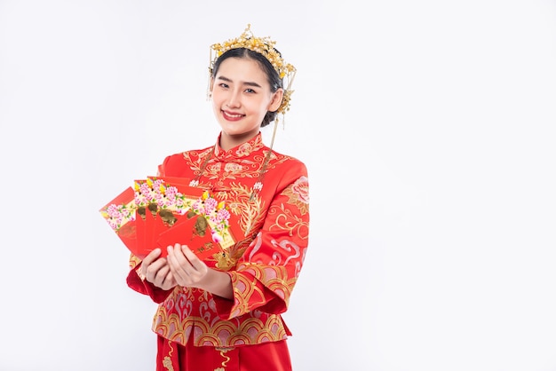 Mujer usa traje Cheongsam sonríe para recibir dinero de regalo del jefe en año nuevo chino