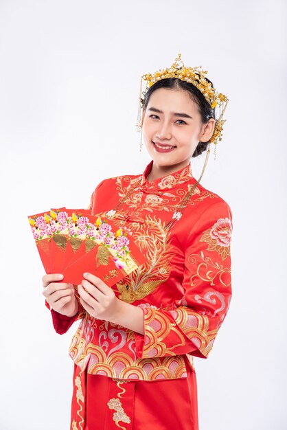 La mujer usa un traje Cheongsam tiene mucha suerte de recibir dinero de regalo de los padres en un día tradicional