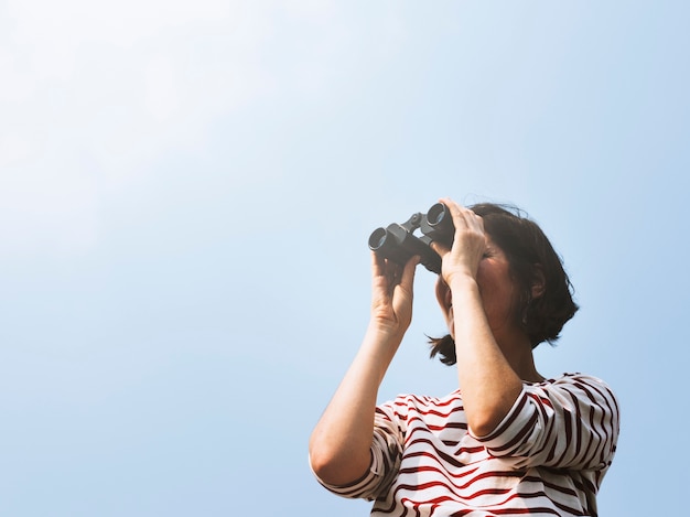 Mujer usando binoculares explorar buscando