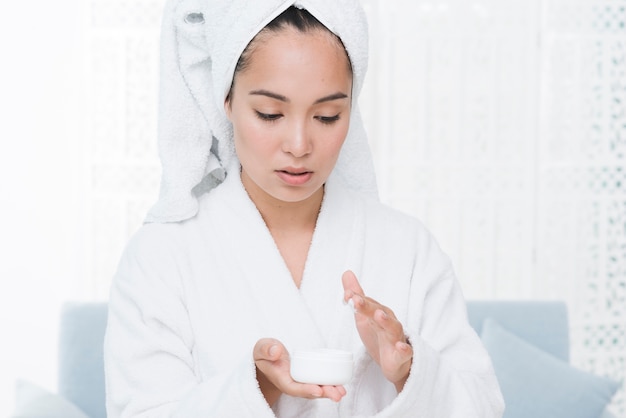 Foto gratuita mujer usando crema de belleza en un spa