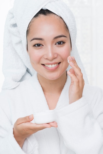 Mujer usando crema de belleza en un spa