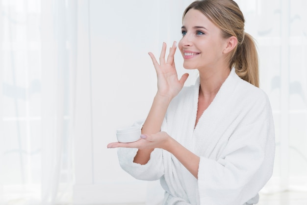 Mujer usando crema de belleza en un spa