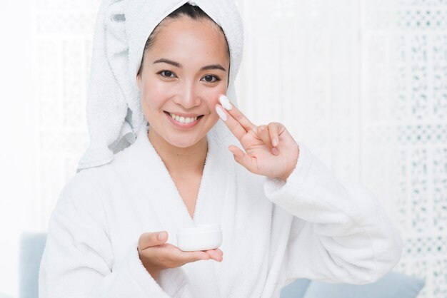 Mujer usando crema de belleza en un spa