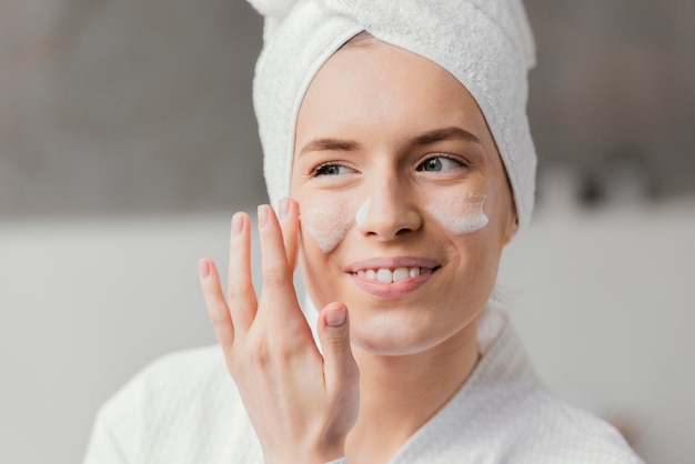 Mujer usando una crema facial blanca