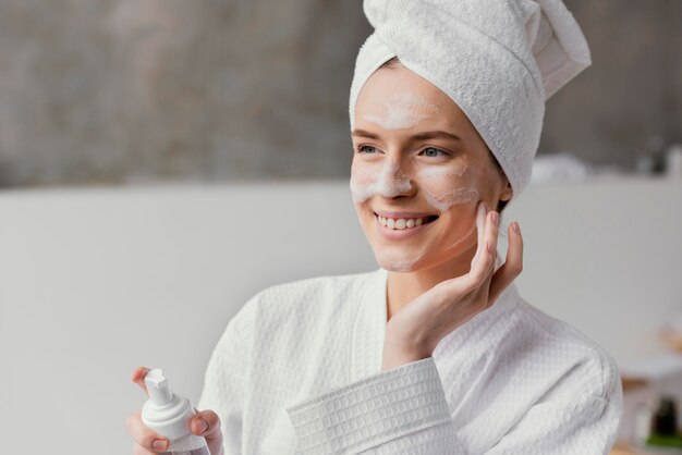 Mujer usando una crema facial blanca