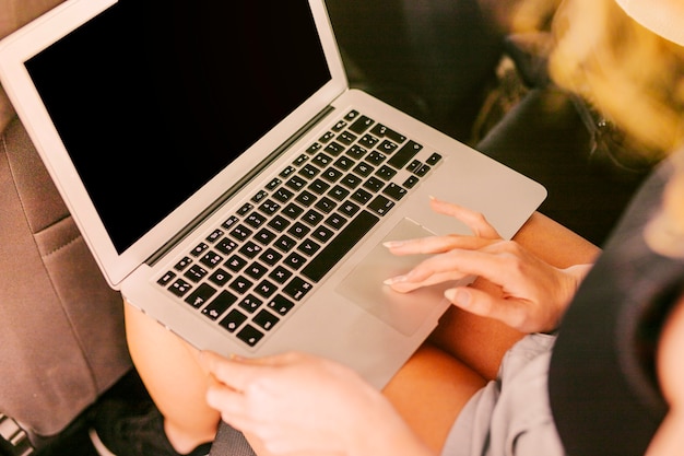 Mujer usando laptop en el asiento trasero del auto