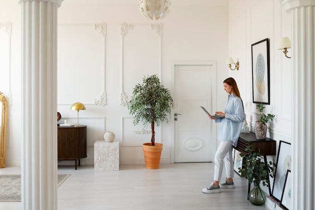 Mujer usando laptop en una habitación mínimamente decorada