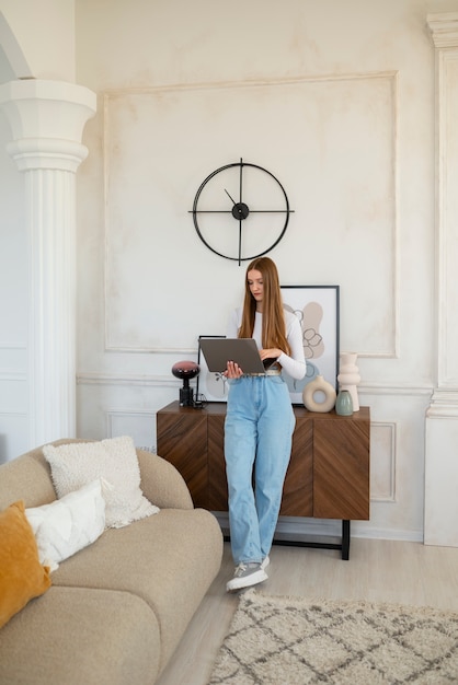 Mujer usando laptop en una habitación mínimamente decorada