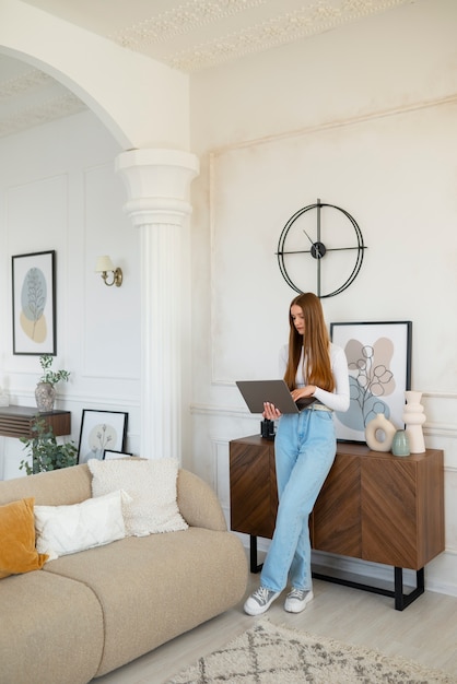 Mujer usando laptop en una habitación mínimamente decorada