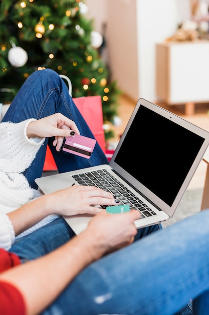 Mujer usando laptop con tarjeta de crédito