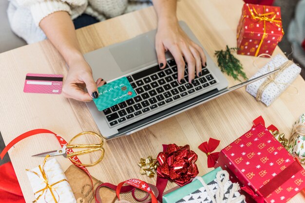 Mujer usando laptop con tarjeta de crédito