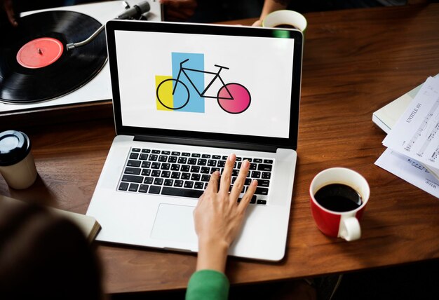 Mujer usando Laptop Wprking con icono de bicicleta en la pantalla