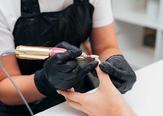 Mujer usando una lima de uñas en el cliente