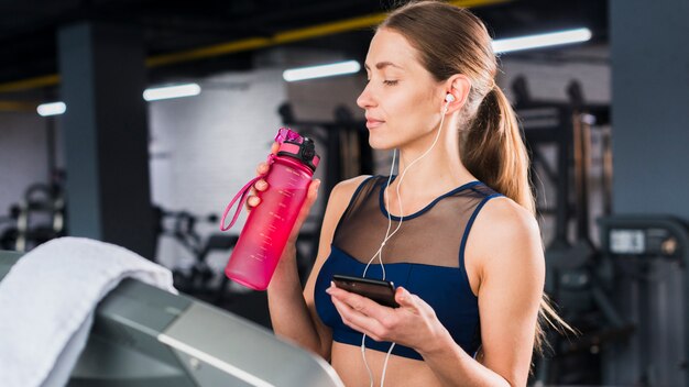 Mujer usando smartphone en gimnasio