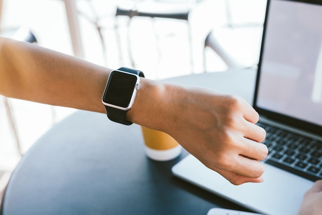 Mujer usando smartwatch con notificador de correo electrónico