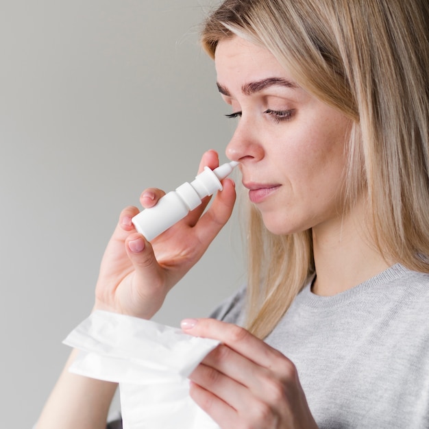 Mujer usando spray nasal