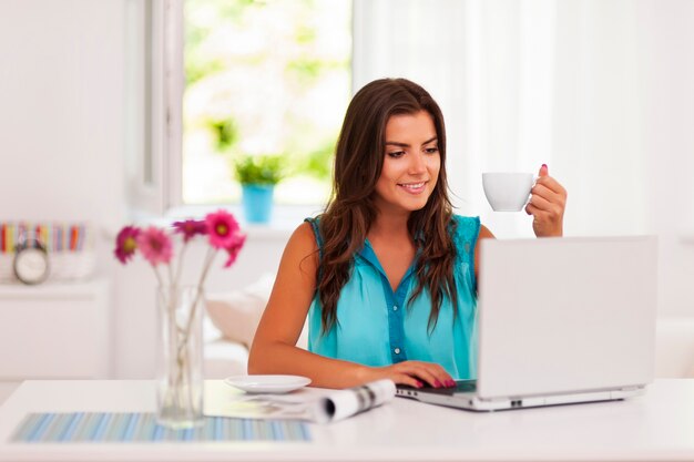 Mujer usando su computadora portátil en casa