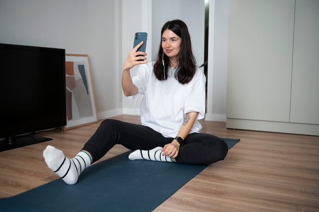 Mujer usando su teléfono inteligente en casa durante la cuarentena