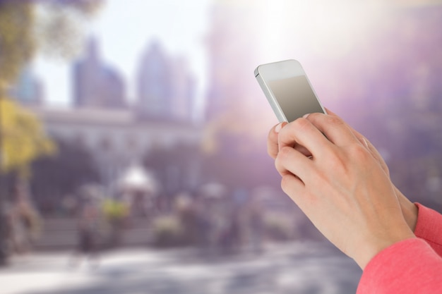 Mujer usando su teléfono móvil sobre fondo borroso