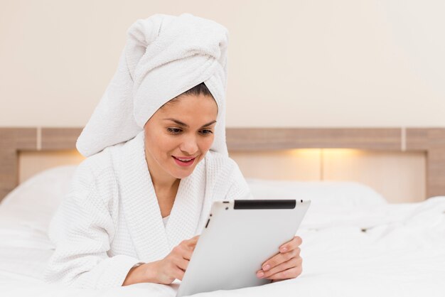 Mujer usando tableta en habitación de hotel