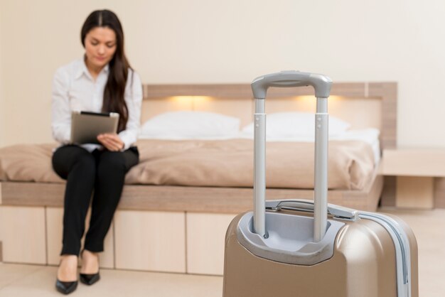 Mujer usando tableta en habitación de hotel