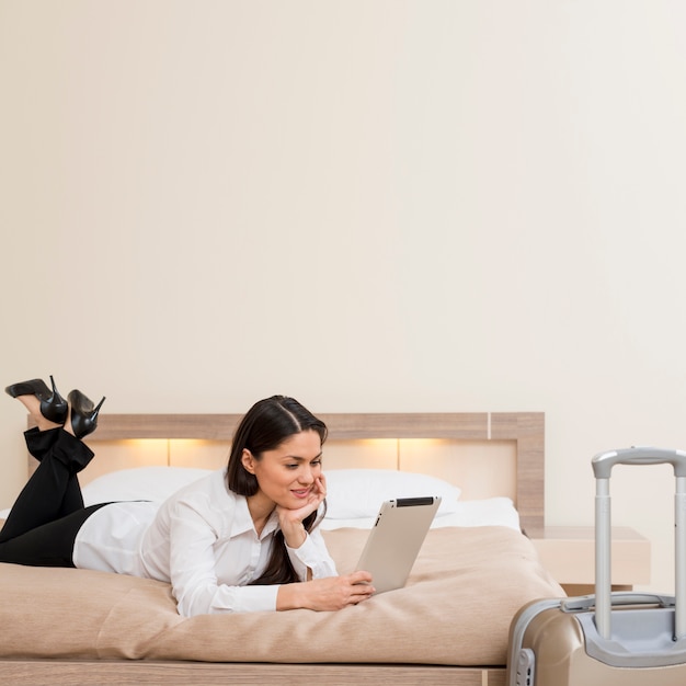 Mujer usando tableta en habitación de hotel