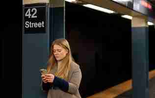 Foto gratuita mujer usando un teléfono inteligente mientras viaja en el metro de la ciudad