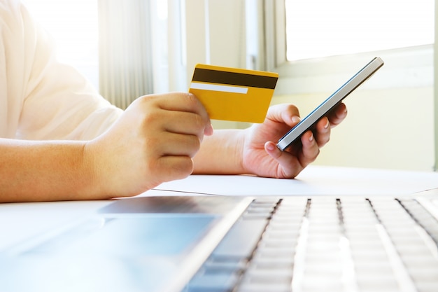 Mujer usando teléfono móvil para comprar en línea y pagar por crédito ca