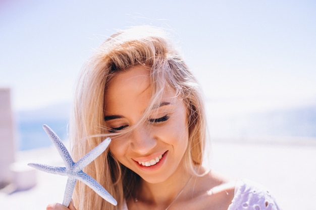 Mujer en unas vacaciones con una estrella de mar