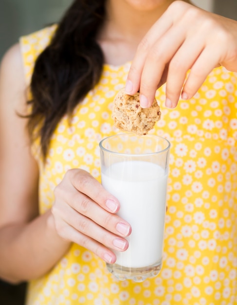 Mujer con vaso de leche y galleta