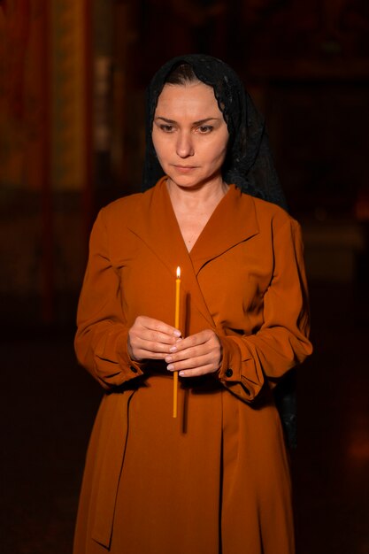 mujer con vela en la iglesia