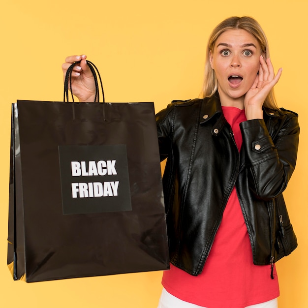 Mujer en venta de viernes negro y gran bolsa de compras