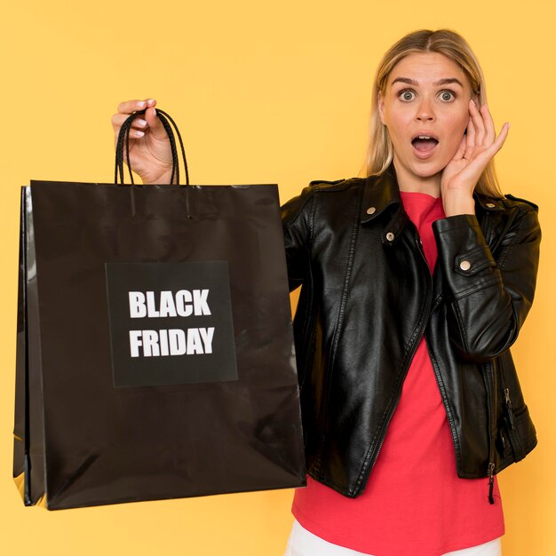 Mujer en venta de viernes negro y gran bolsa de compras