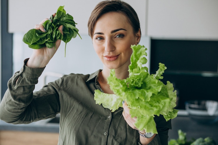 Foto gratuito mujer con verduras verdes en la cocina