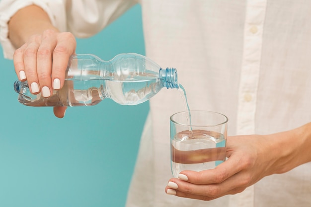 Foto gratuita mujer vertiendo agua en un vaso