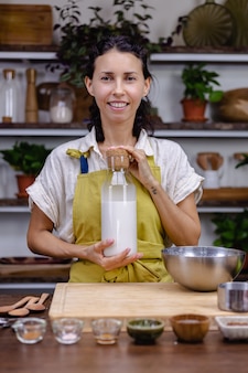 Mujer vertiendo leche de almendras en botella de vidrio