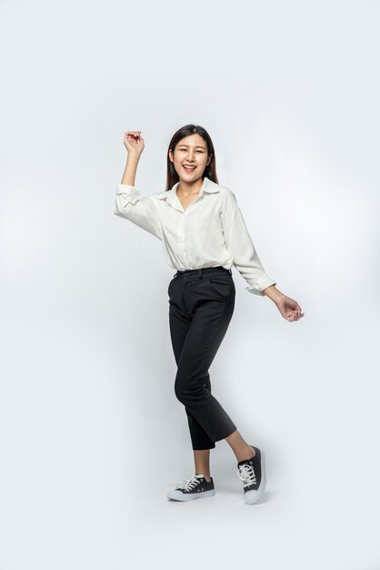 La mujer vestía camisa blanca y pantalón oscuro e hizo una pose divertida