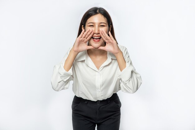 La mujer vestía camisa blanca y pantalón oscuro y hace un grito de alegría