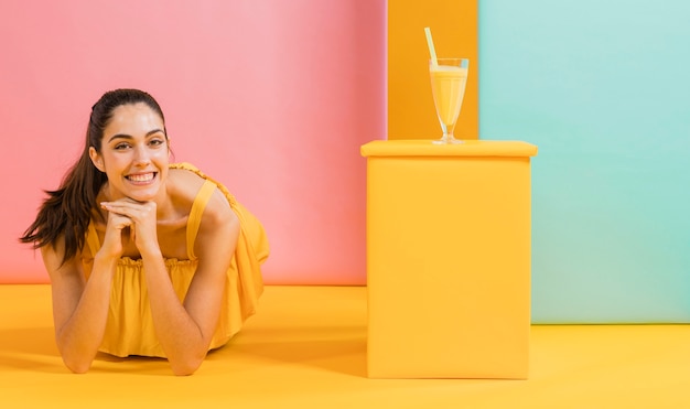 Mujer vestida de amarillo con un vaso de jugo