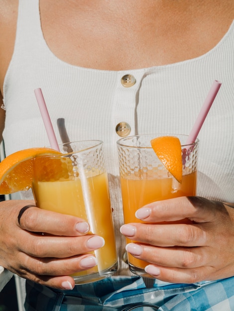 Mujer vestida de blanco con vasos de jugo