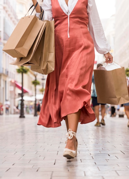 Mujer vestida con bolsa de compras en la calle