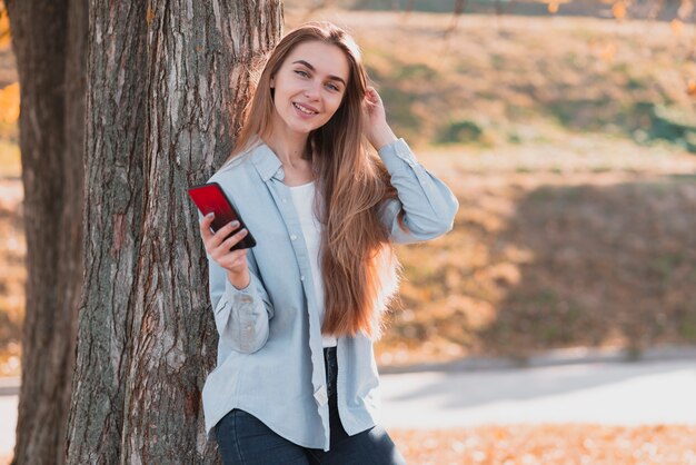 Mujer vestida casual que sostiene un teléfono