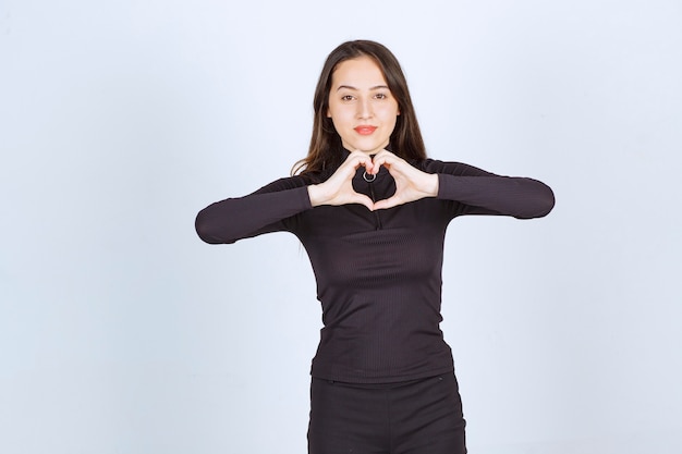 Mujer vestida de negro sintiéndose encantadora y romántica.