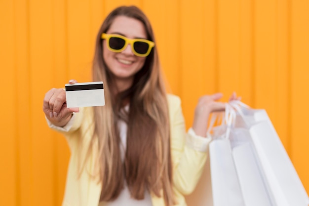 Mujer vestida con ropa amarilla con tarjeta de compras