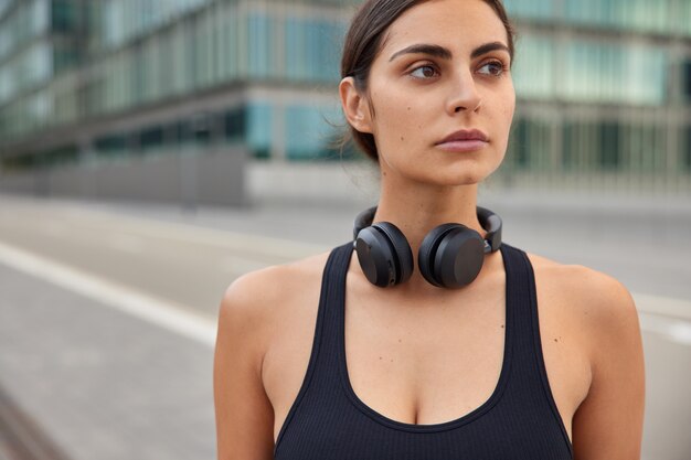 Mujer vestida con ropa deportiva descansa después de poses de entrenamiento en la carretera va al gimnasio