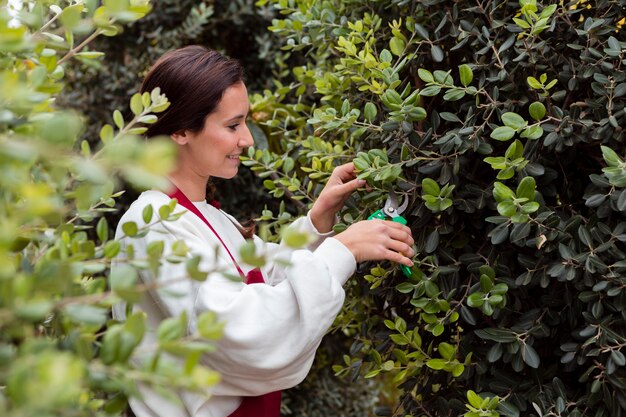 Mujer vestida con ropa de jardinería podar setos