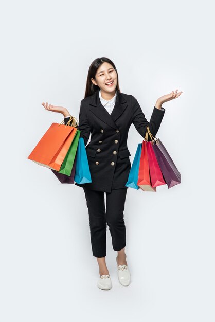 La mujer vestida con ropa oscura, junto con muchos bolsos, para ir de compras