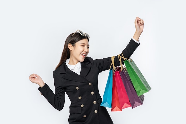 La mujer vestida con ropa oscura, junto con muchos bolsos, para ir de compras