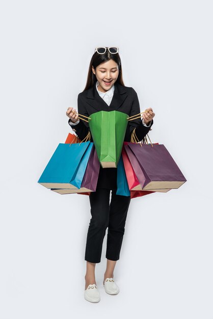 La mujer vestida con ropa oscura, junto con muchos bolsos, para ir de compras